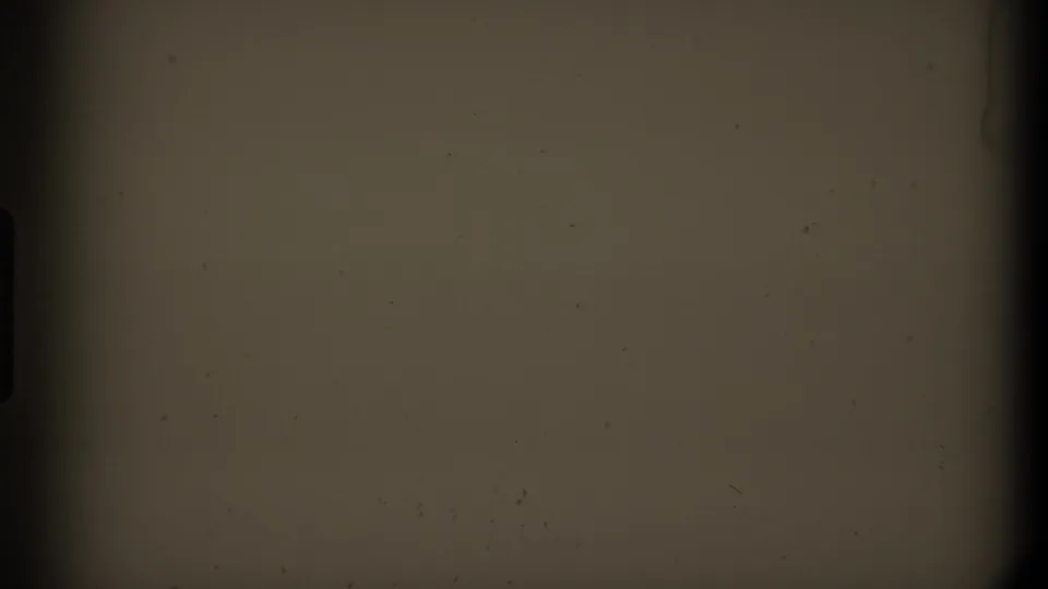 Dark warm-toned 8mm frame associated with the 1980 Mendocino clip metadata, showing blank film texture and gate shadowing.