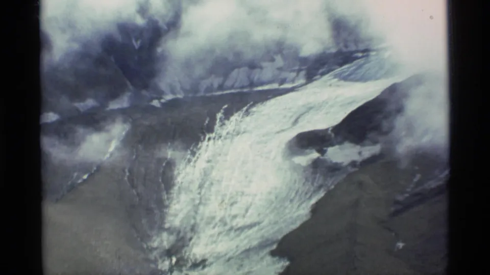 1977 Alaska home-movie view of a broad icy slope with steam or smoke drifting above the landscape.