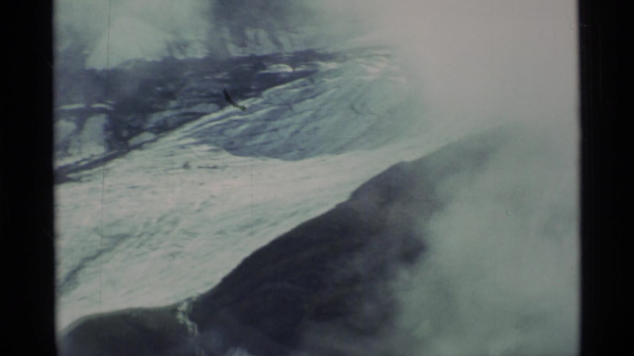 Aerial view of icy mountain slopes partly covered by mist.