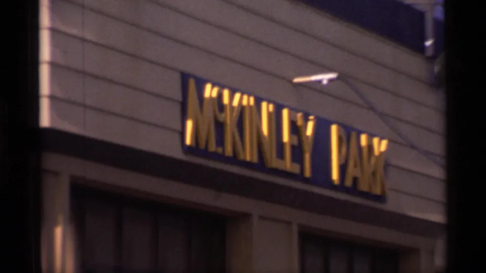 1977 Alaska 8mm frame showing a building facade with a visible McKinley Park sign, filmed from below.
