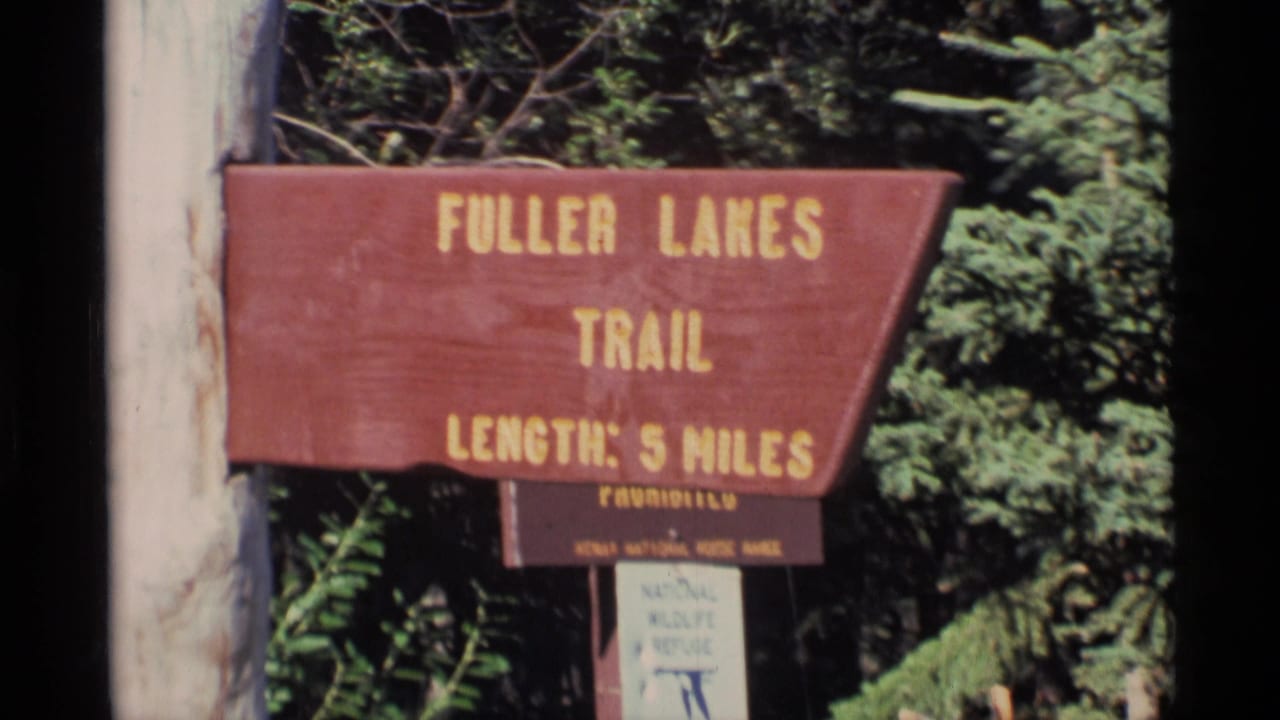 Wooden Fuller Lakes Trail sign among trees with length marked as 5 miles.