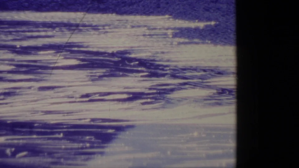 1977 Alaska 8mm frame emphasizing layered snow or ice textures with blue-purple color shift and visible film wear.