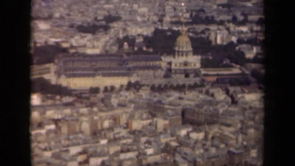 1939 Paris frame from an elevated viewpoint, with the Les Invalides dome centered among urban blocks and trees.
