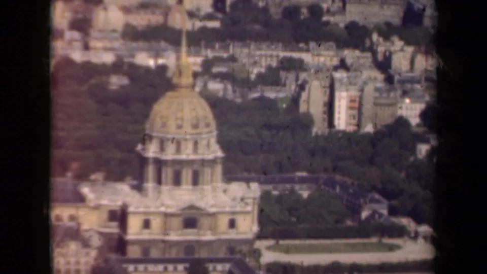 Closer 1939 Paris aerial frame showing the gilded Les Invalides dome above trees, rooftops, and nearby streets.