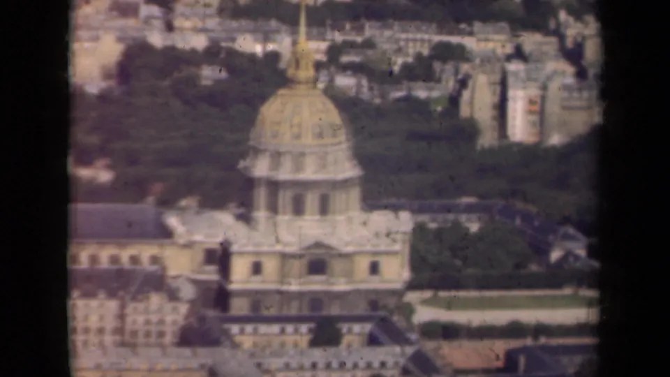 1939 Paris home-movie frame showing the golden dome of Hôtel des Invalides, long building wings, trees, and distant rooftops.