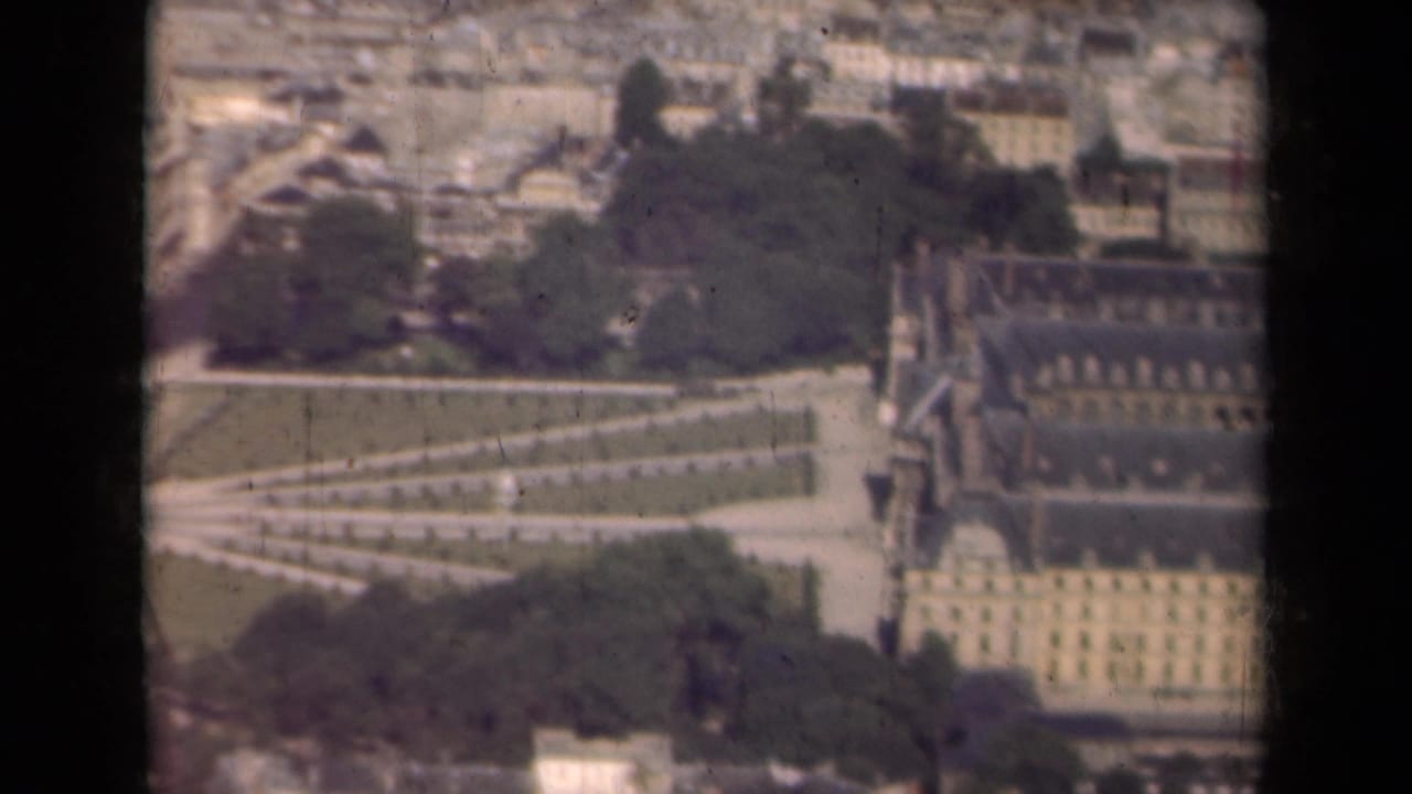Aerial view of the Louvre area and nearby gardens divided by a dark vertical window frame.
