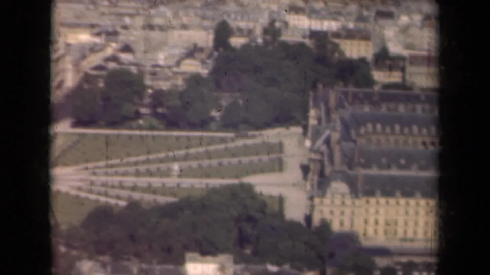 Paris aerial view from 1939 with the Louvre area, garden geometry, rooftops, and dark aircraft-window framing visible.