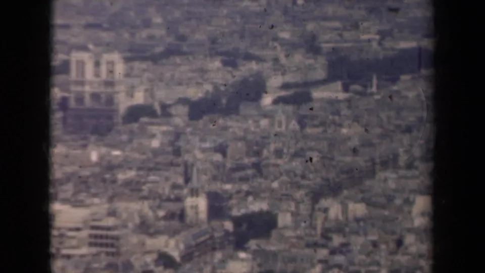 1939 Paris aerial frame showing Notre-Dame within a dense historic cityscape, softened by grain and haze.