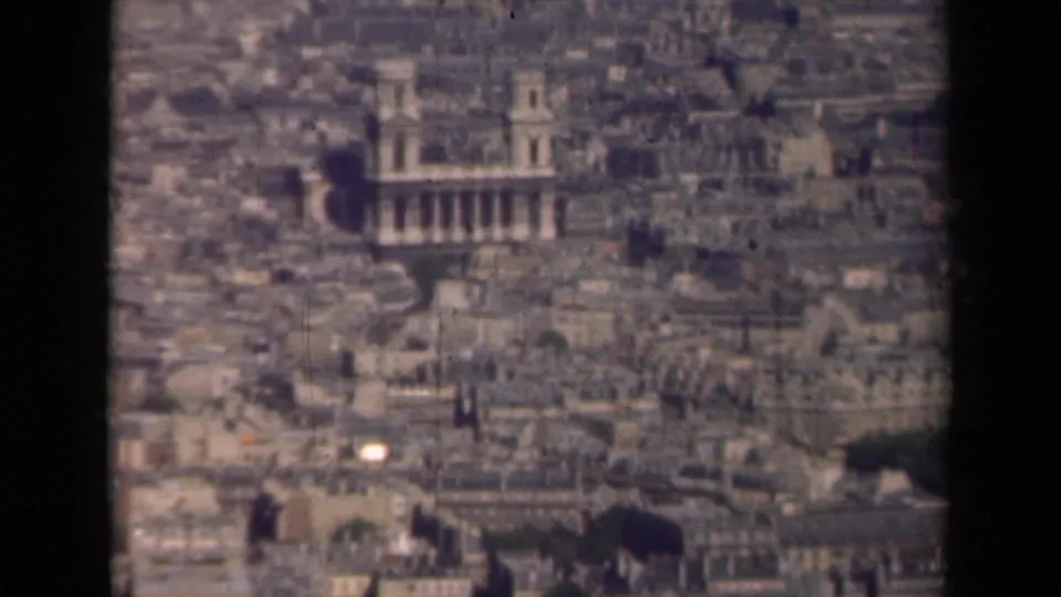 Late-1930s Paris aerial home-movie frame with a prominent columned building, surrounding rooftops, and visible 8mm frame edges.