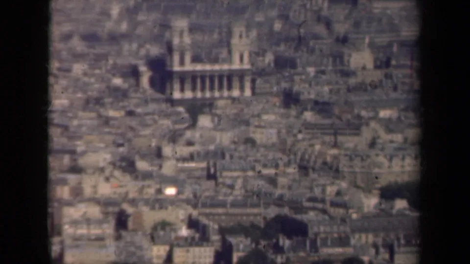 1939 8mm view over Paris rooftops with a prominent landmark building and surrounding urban blocks.