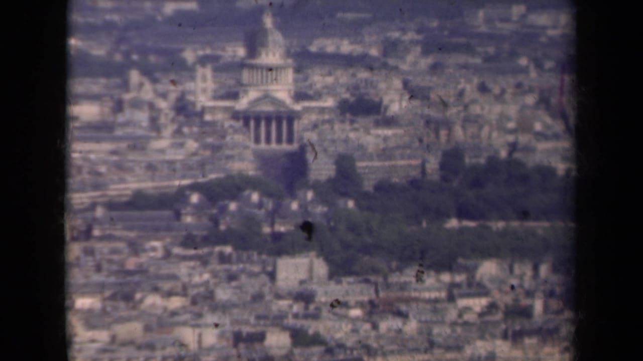 Distant elevated view of the Invalides dome over Paris rooftops.