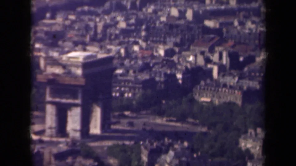 Soft 8mm frame from Paris in 1939 showing a closer high-angle look at the Arc de Triomphe, nearby trees, and surrounding urban blocks.