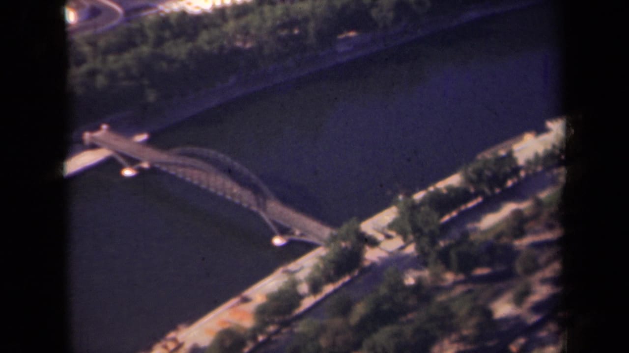 1939 Paris aerial view showing the Seine, a bridge, riverside trees, and dark vertical edges from a window or film gate.