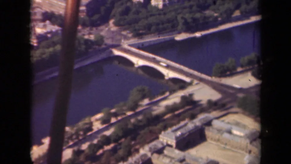 1939 Paris aerial view with a multi-arch bridge crossing the Seine, tree-lined banks, nearby buildings, and visible dark borders.