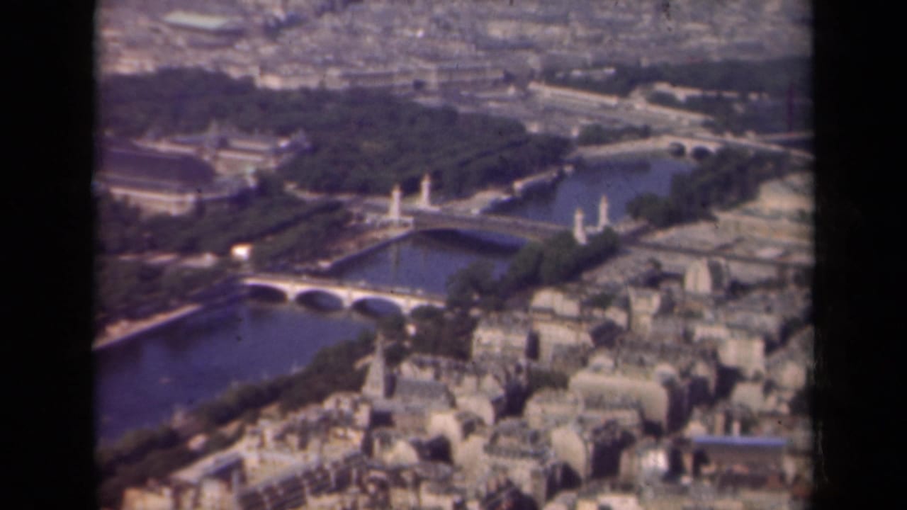 1939 aerial view of Paris with Pont Alexandre III visible across the Seine, surrounded by gardens, bridges, and urban blocks.