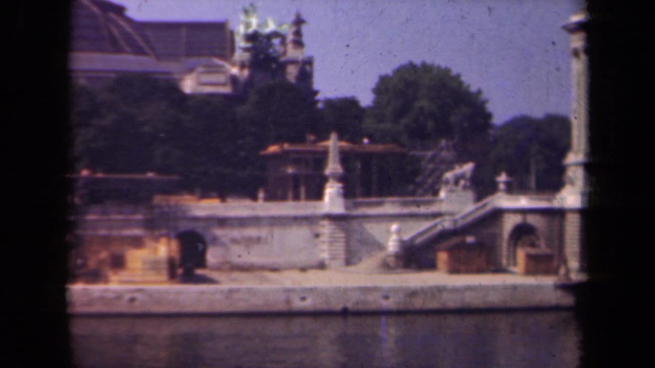 1939 Paris footage showing a stone riverside structure with stairs, a tall column, trees, and ornate architectural details.