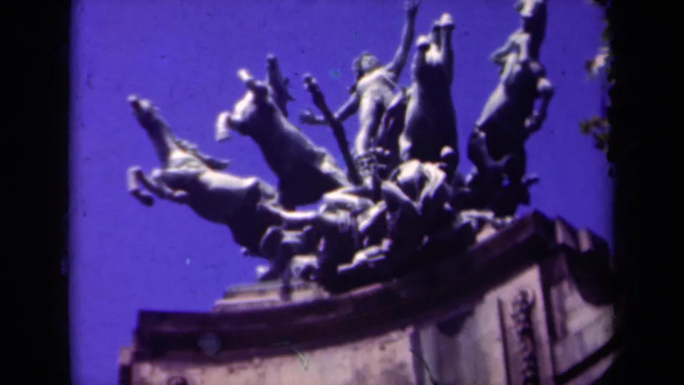1939 Paris travel-film frame showing a monumental sculptural group with rearing horses, raised sword, and visible 8mm frame edges.