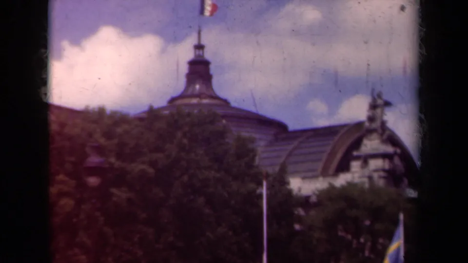 The final 1939 Paris frame holds on the flag, dome, roof, trees, and ornate architectural detail at frame right.