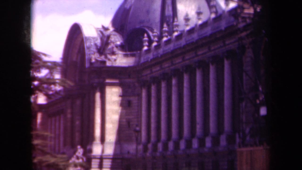 1939 Paris 8mm frame showing a grand stone facade with tall columns, ornate roofline, and a domed structure above.