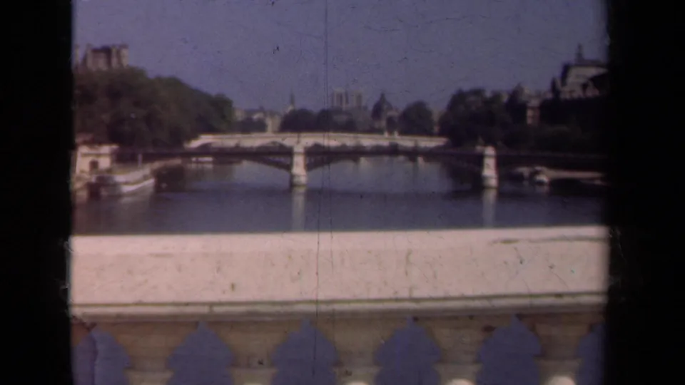 1939 Paris frame with the Seine, bridge, Notre-Dame in the distance, and visible 8mm wear across the image.