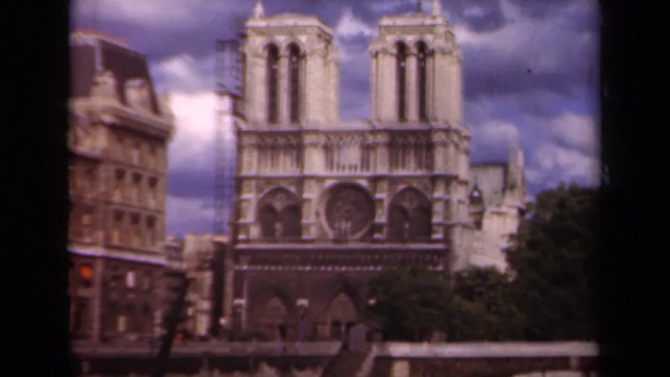 Final 1939 Paris frame of Notre-Dame Cathedral, showing the twin towers, rose window, scaffolding, trees, and riverside parapet.