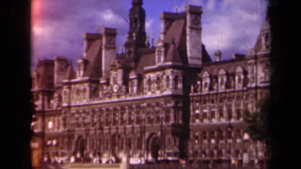 Final 1939 Paris frame holds on the Hôtel de Ville facade, with towers, mansard roofs, arched entries, and warm faded 8mm color.