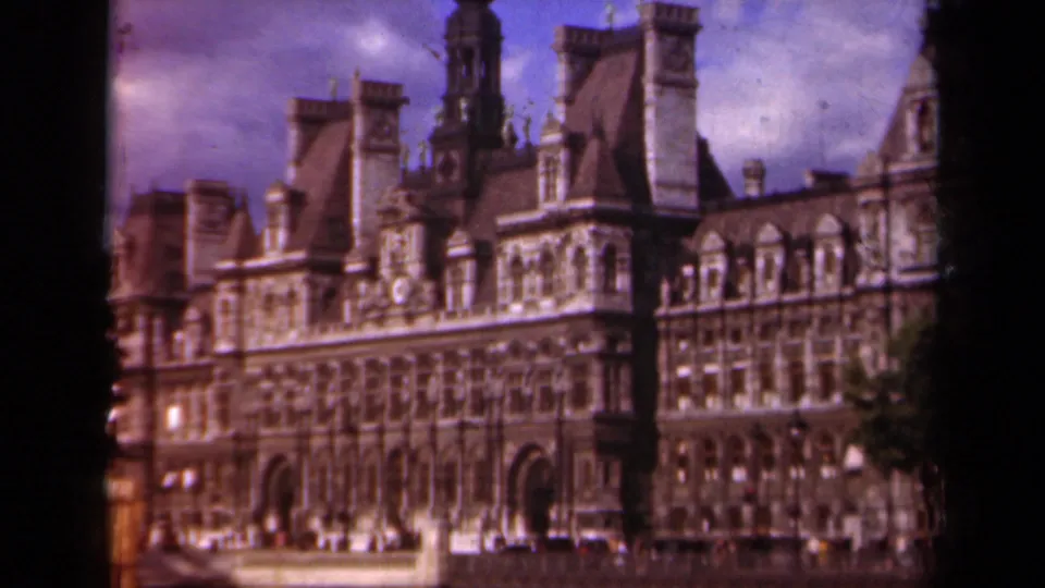 1939 Paris 8mm view of a grand ornate stone building with towers, arched entrances, and small figures near the facade.