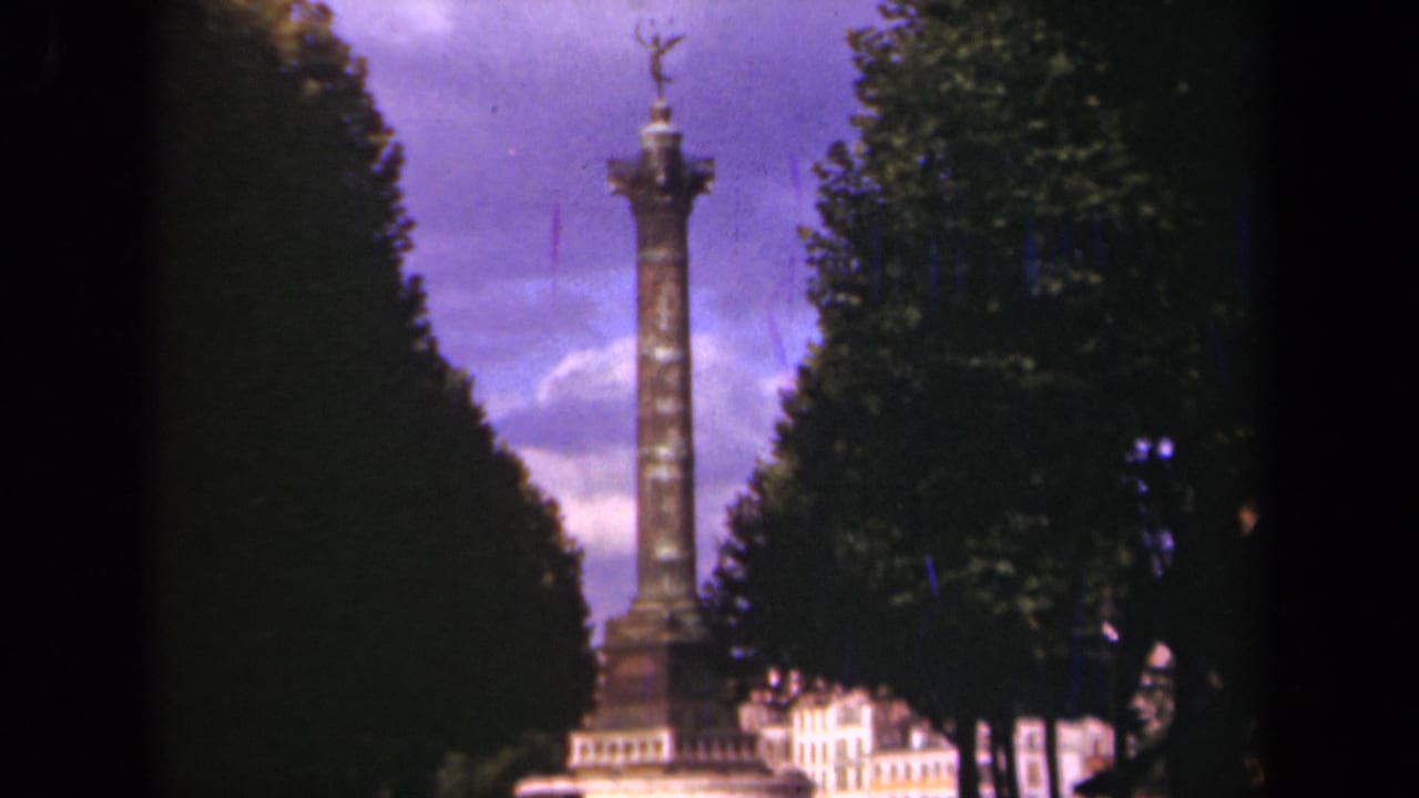 Final 1939 Paris frame holding on the column monument, dark foliage, pale buildings, and color-shifted sky.