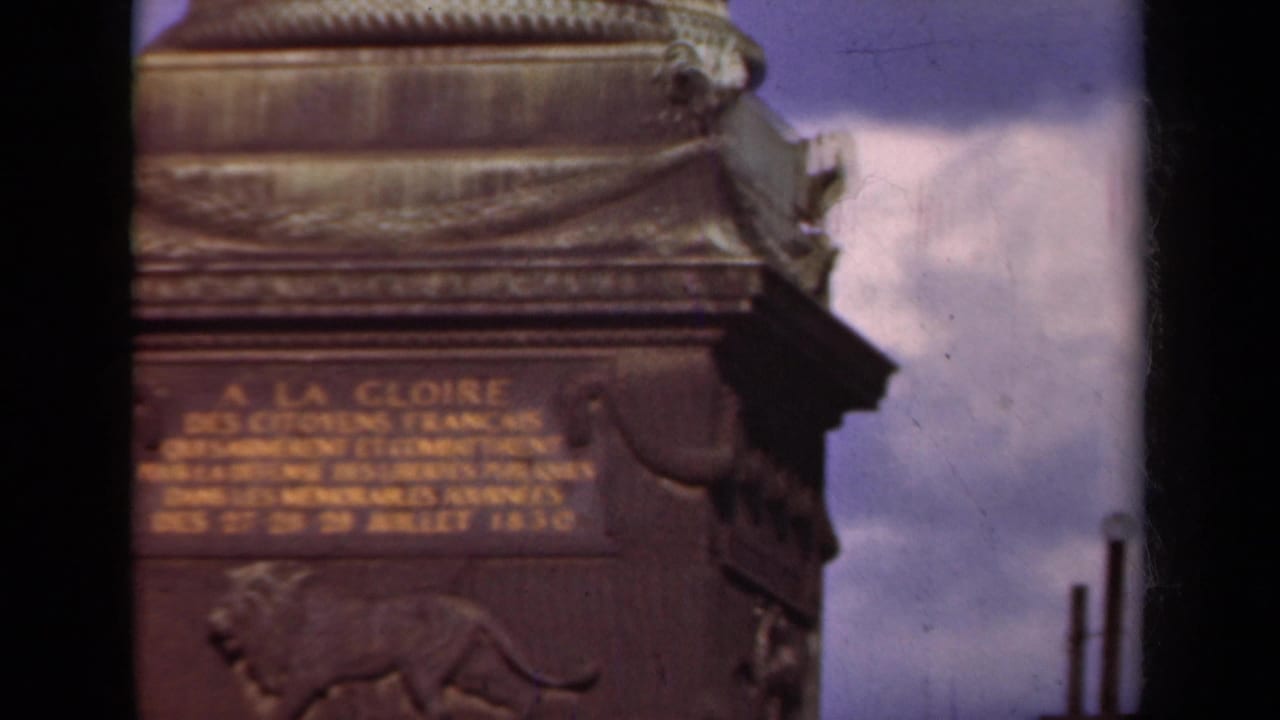 1939 Paris 8mm close-up of Arc de Triomphe inscription detail, with lion relief below and cloudy sky at the side.