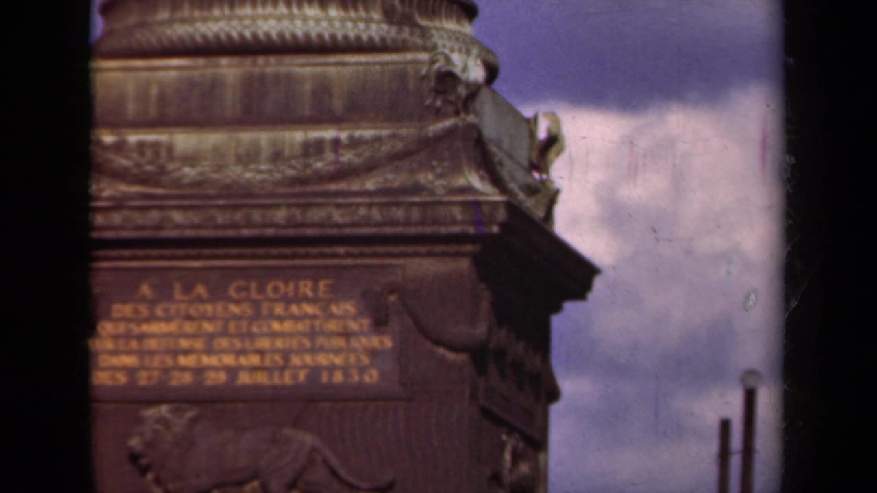 Similar close view of the monument inscription, carved base, and bronze relief against sky.