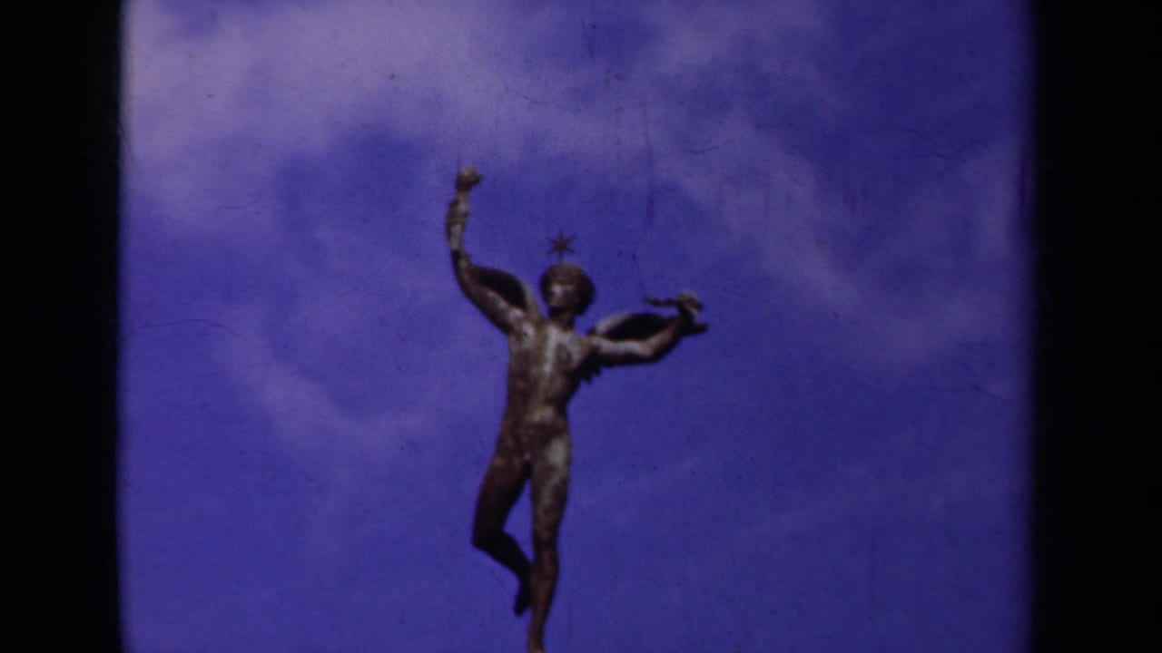 1939 Paris frame with the winged male statue held near center, one arm lifted above a cloudy blue sky.