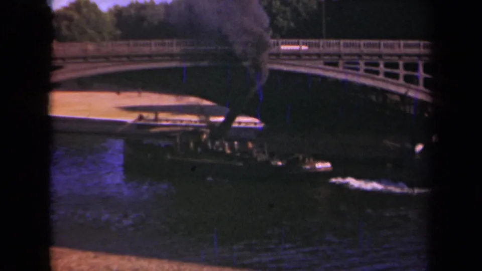 A small steam boat under or beside a Paris bridge in 1939, with heavy smoke, rippled water, and bridge railings visible.