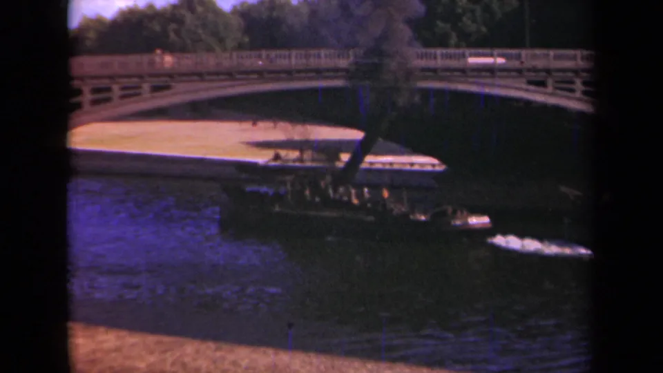Late frame of the 1939 Paris boat shot, with the vessel near the bridge, smoke rising, and the river or canal surface below.