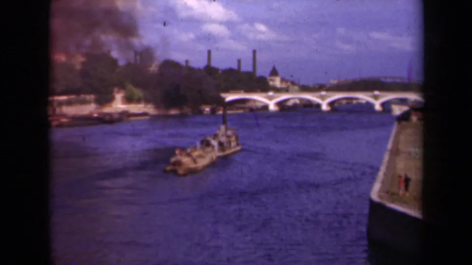 Final 1939 Paris frame shows the barge farther across the Seine, with a white arched bridge and smoke over the riverbank.