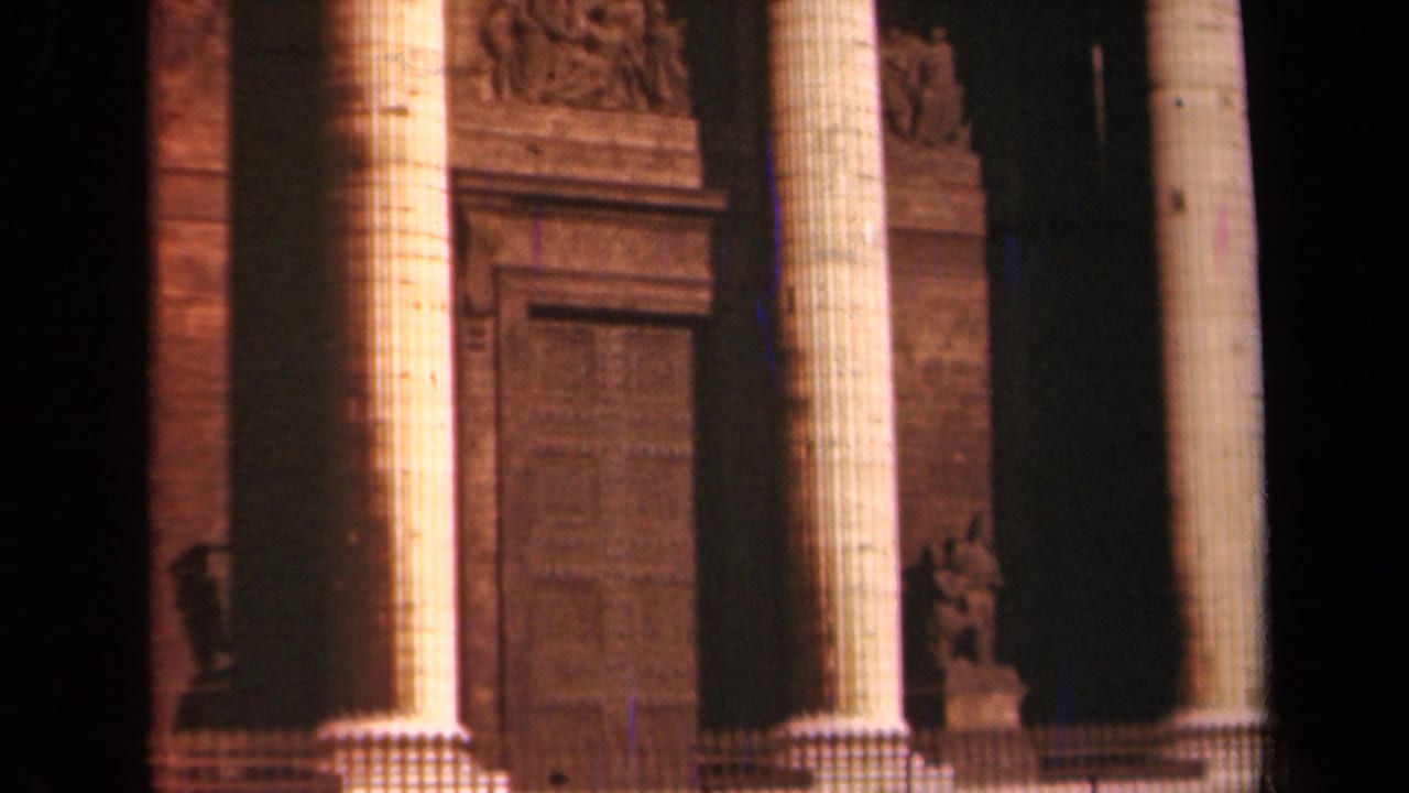 1939 Paris 8mm frame showing tall fluted columns, carved stonework, and a large doorway on a monumental facade.