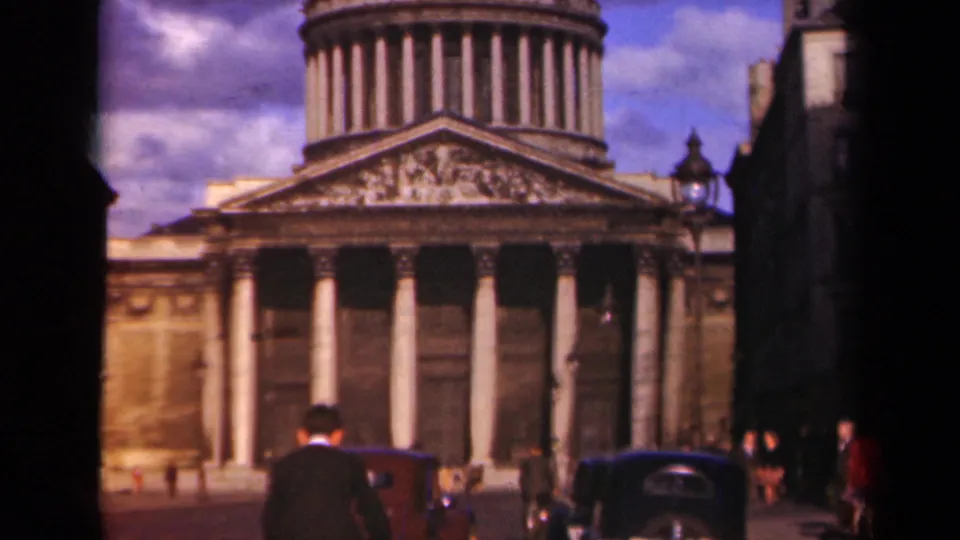 Wide 1939 Paris street view of a domed neoclassical landmark, vintage automobiles, pedestrians, and surrounding buildings.