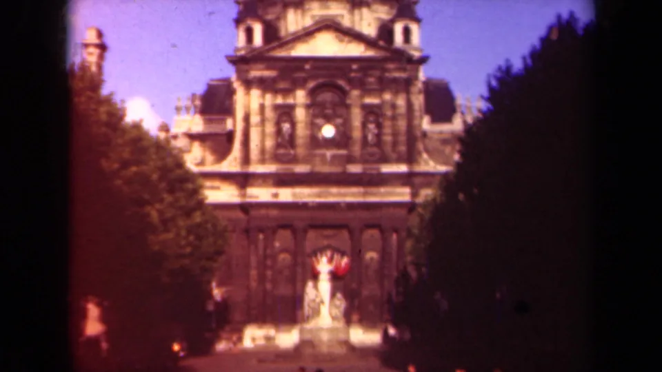 1939 Paris 8mm still of Hôtel des Invalides with a central statue or fountain, tree shadows, and visible gate or edge artifacts.
