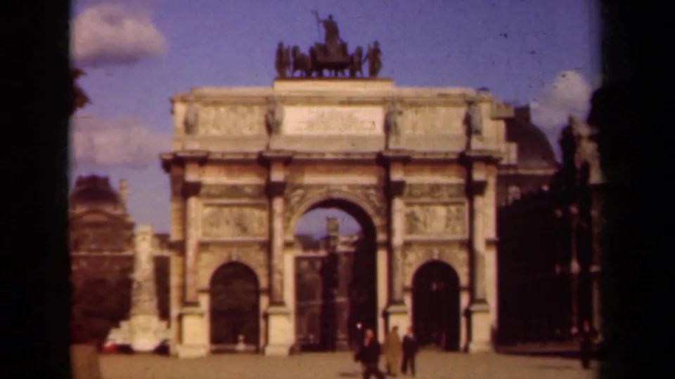 1939 Paris 8mm frame showing a triumphal arch with a chariot sculpture above and pedestrians crossing the foreground.