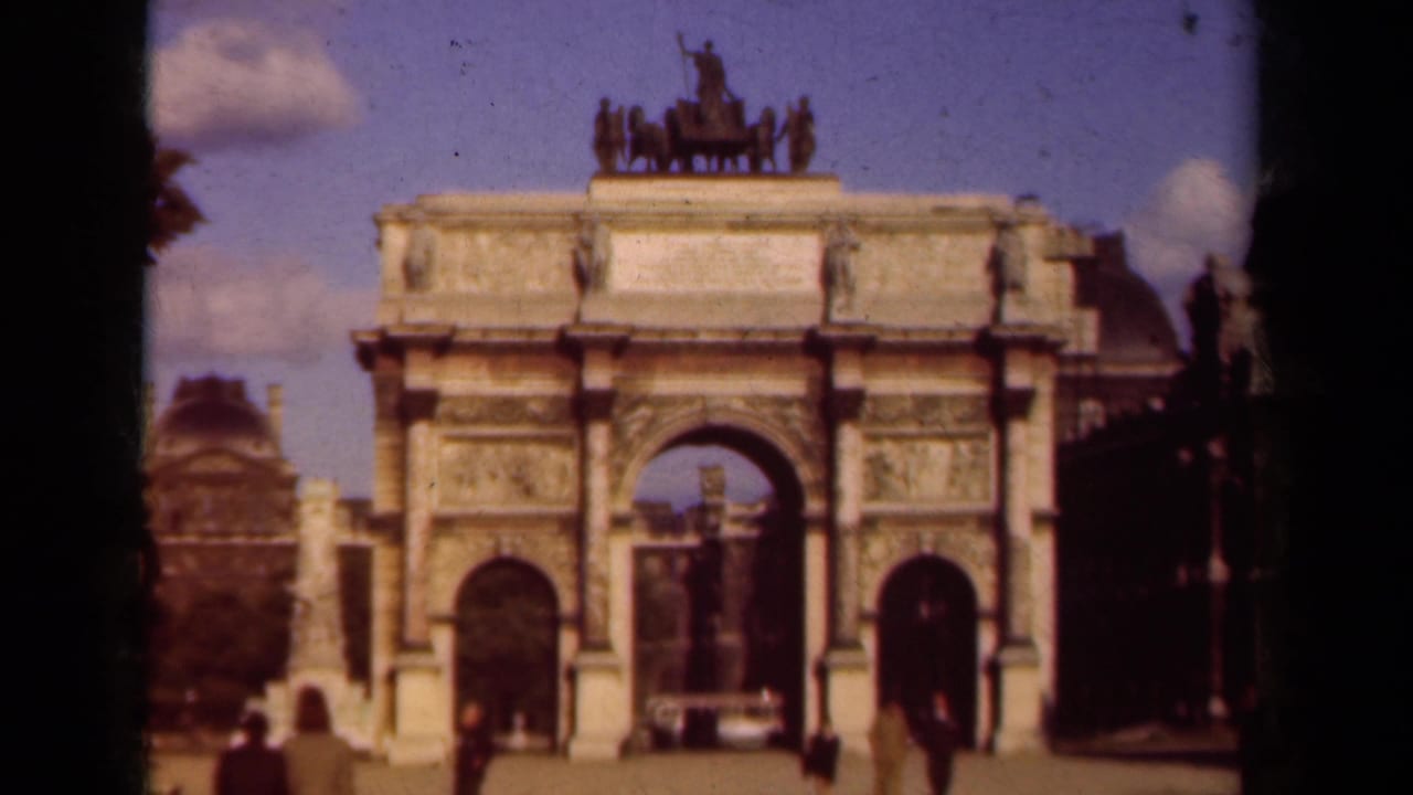 1939 Paris landmark view with pedestrians near the arch and a light-colored vehicle passing through the scene.