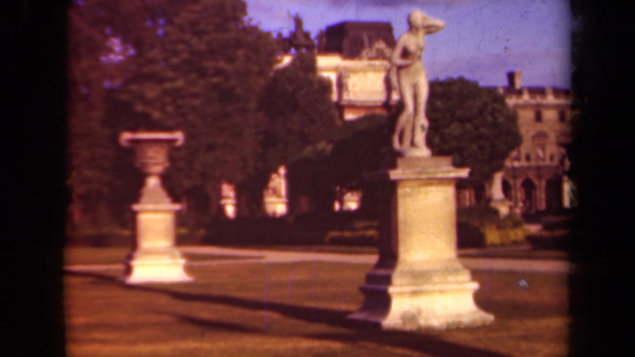 1939 Paris frame with a classical figure sculpture on a pedestal near an urn in a formal park.