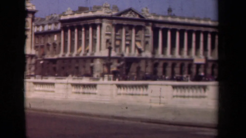 1939 Paris frame showing a classical facade with tall columns, decorative roofline, stone balustrade, and roadway in the foreground.