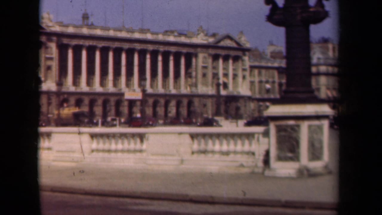 Classical Paris buildings and a stone balustrade seen from across a public square.