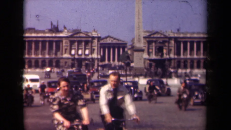 Paris, France, 1939: cyclists cross the foreground at Place de la Concorde while automobiles and pedestrians move through the square.