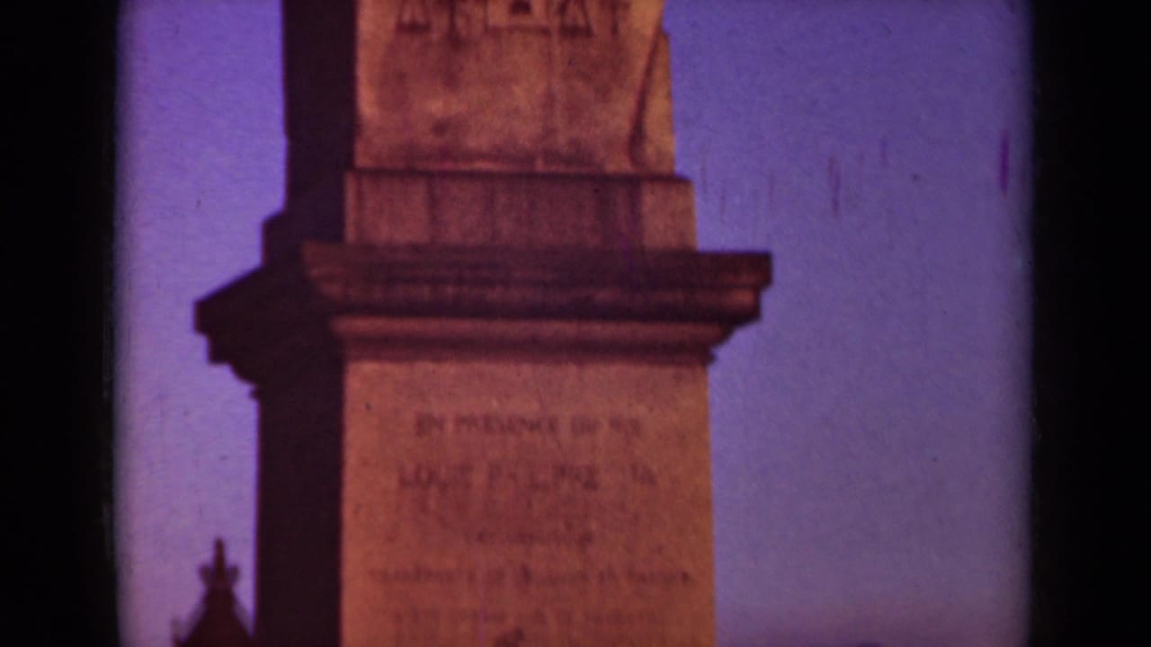 Stone obelisk base and upper carving against a purple-blue sky.