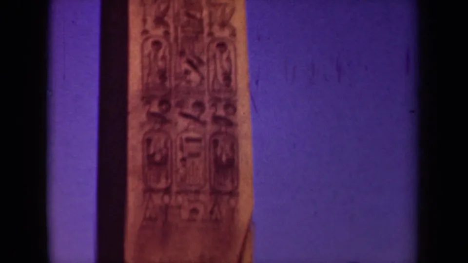 Close 8mm view of the Paris obelisk surface, showing vertical Egyptian-style carvings against a saturated twilight sky.