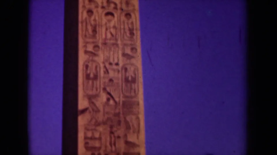 Final 1939 Paris frame holds on the obelisk's carved vertical surface, with warm stone color and blue-purple sky.