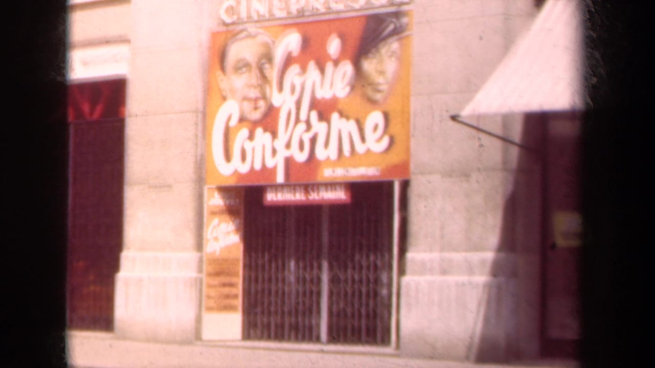 Cinema facade with orange Copie Conforme poster, stone columns, awning, and metal gate.
