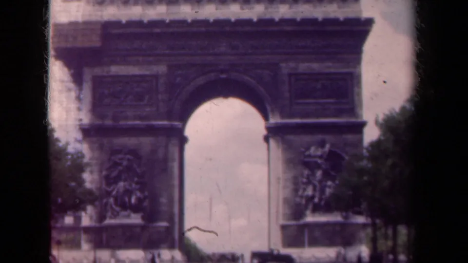 Closer 1939 Paris view of the Arc de Triomphe showing the central arch, relief sculpture, trees, and soft 8mm color.