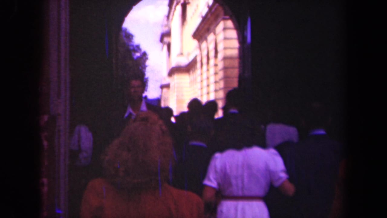 A group of visitors continues through the arch toward the exterior courtyard.