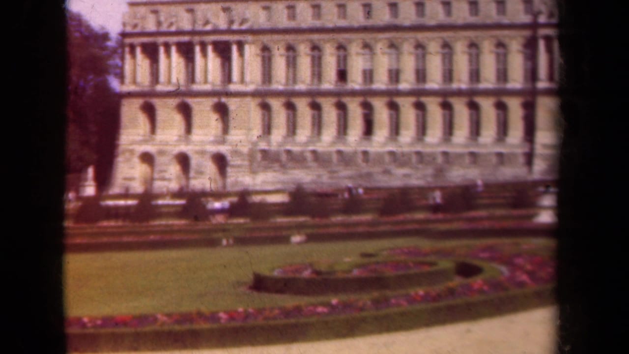 1939 Paris home-movie view of formal lawns, magenta flowerbeds, and an ornate palace-like facade.
